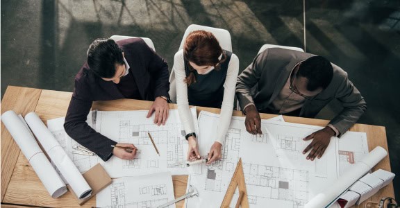 group of architects drawing blueprint