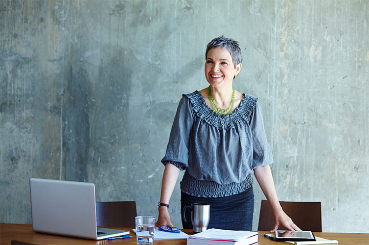 Person standing at desk smiling