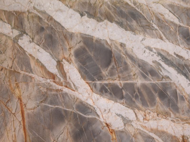 Close-up of a marble slab with gray, white, and brown veining.