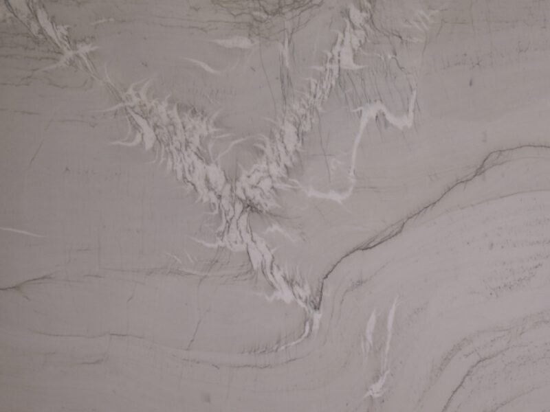 Close-up of white marble surface with natural veining and texture.