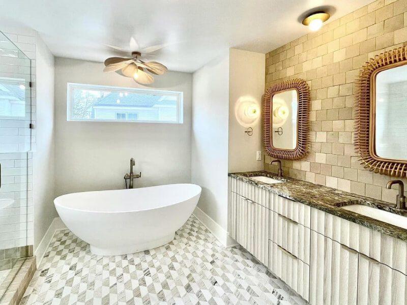 Bright bathroom with freestanding bathtub, double vanity, and natural light.