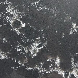 Close-up of black granite with white mineral specks and natural patterns.