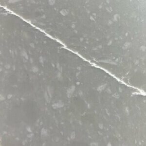 Close-up of gray granite with white natural veining and speckled texture.
