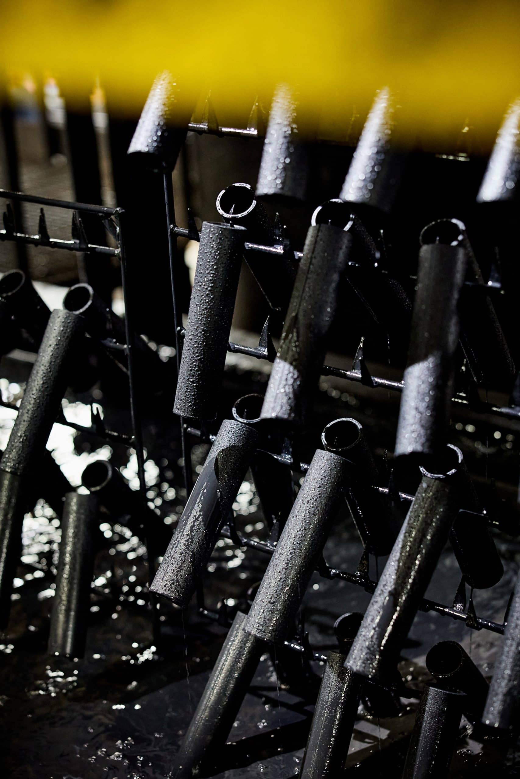 Close-up of black water fountain nozzles with water droplets, for website renaming and branding.