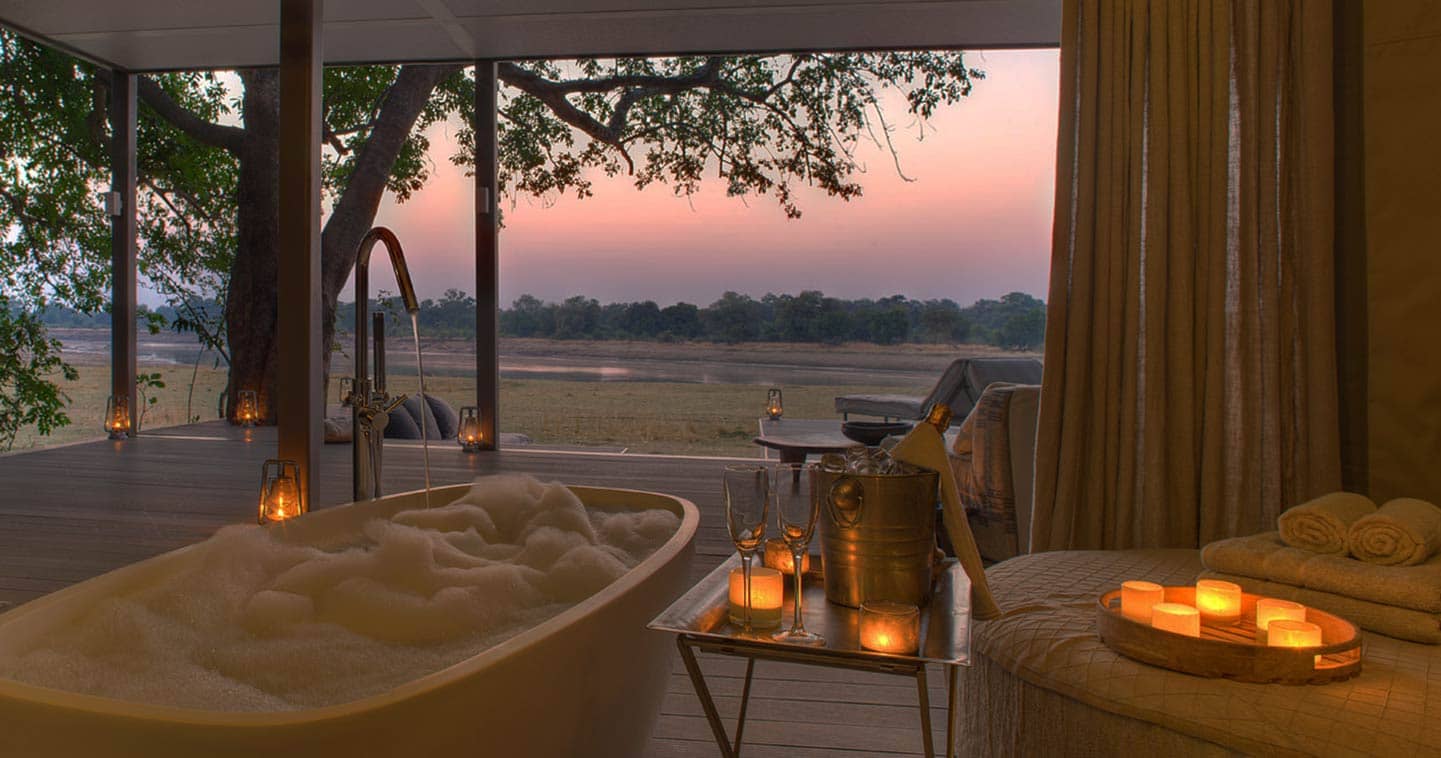 Luxury Safari Lodge with Indoor bathroom with a sunset view of african bush