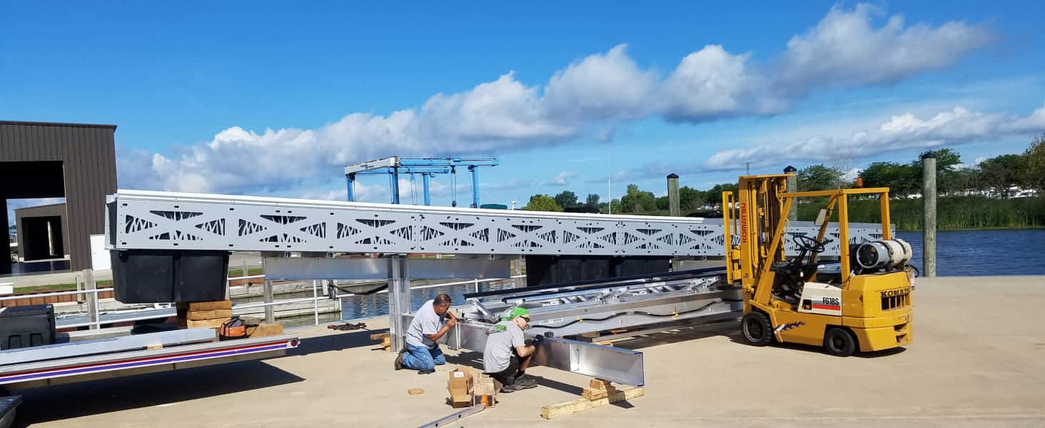 Dock construction with workers and equipment at Summit Marine facility.