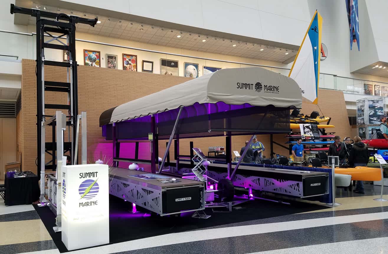 Innovative boat display by Summit Marine with LED lighting at an indoor event.