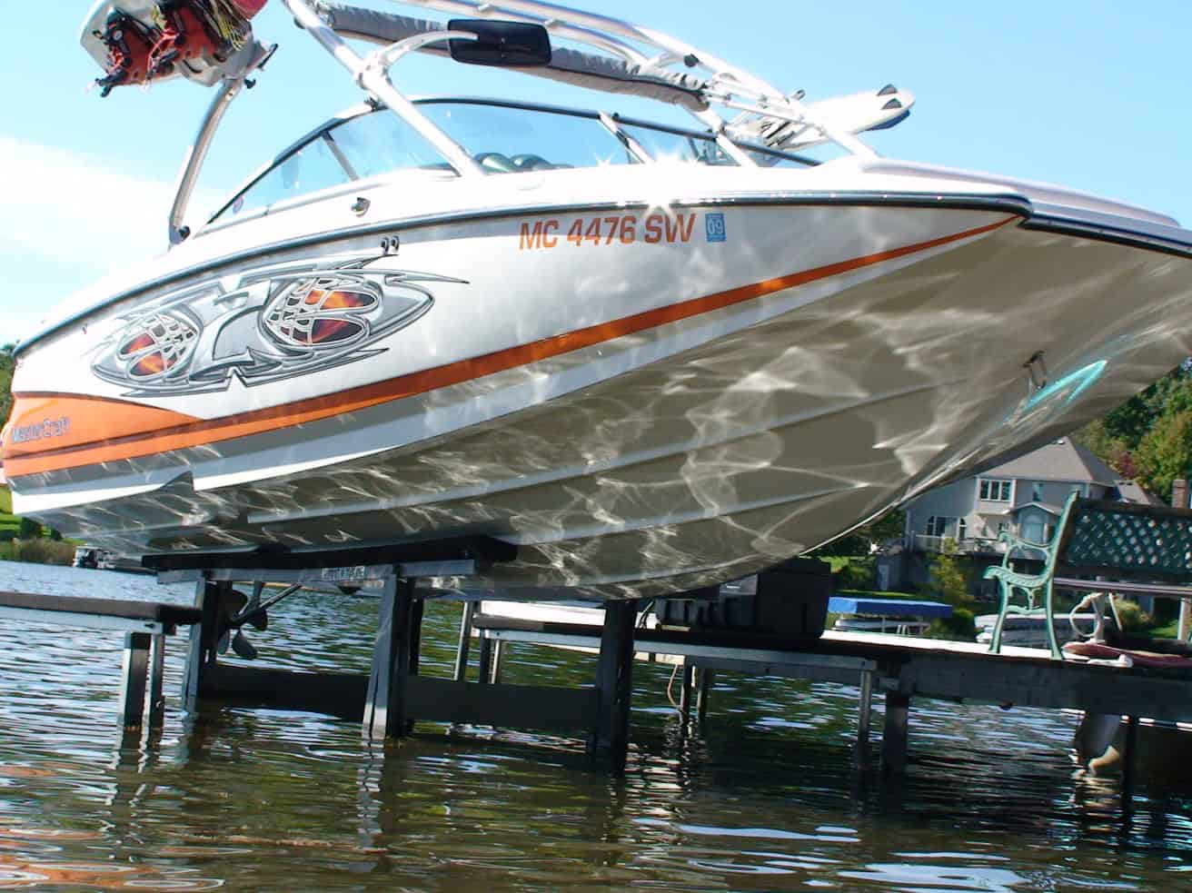 Speedboat docked at marina with clear water and blue sky background.