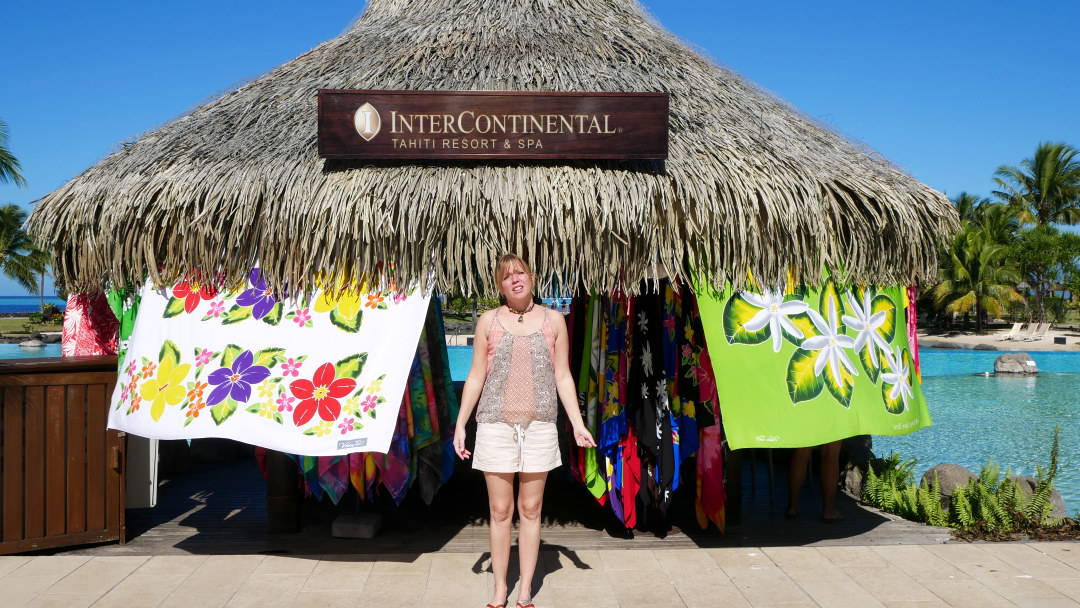 Emily standing in front of a hut