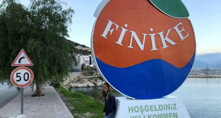 Emily leaning on Finike City Sign