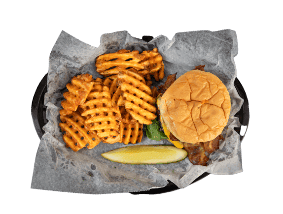 Waffle fries, burger, and lemon wedge on a black tray with parchment paper.