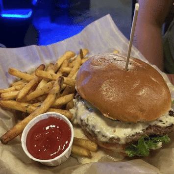 Juicy burger with fries and ketchup at The Holiday Bar.