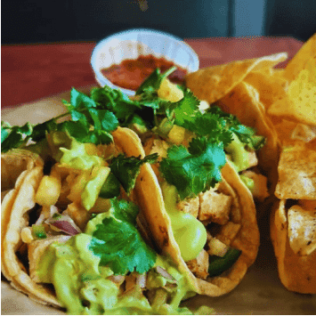 Delicious tacos with fresh cilantro, guacamole, and crispy chips at The Holiday Bar.