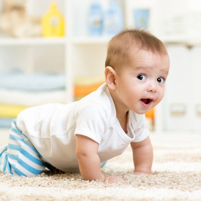 baby crawling on daycare carpet
