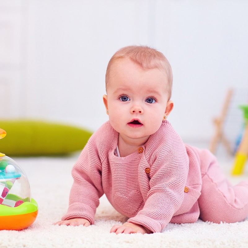 baby girl crawling on daycare floor