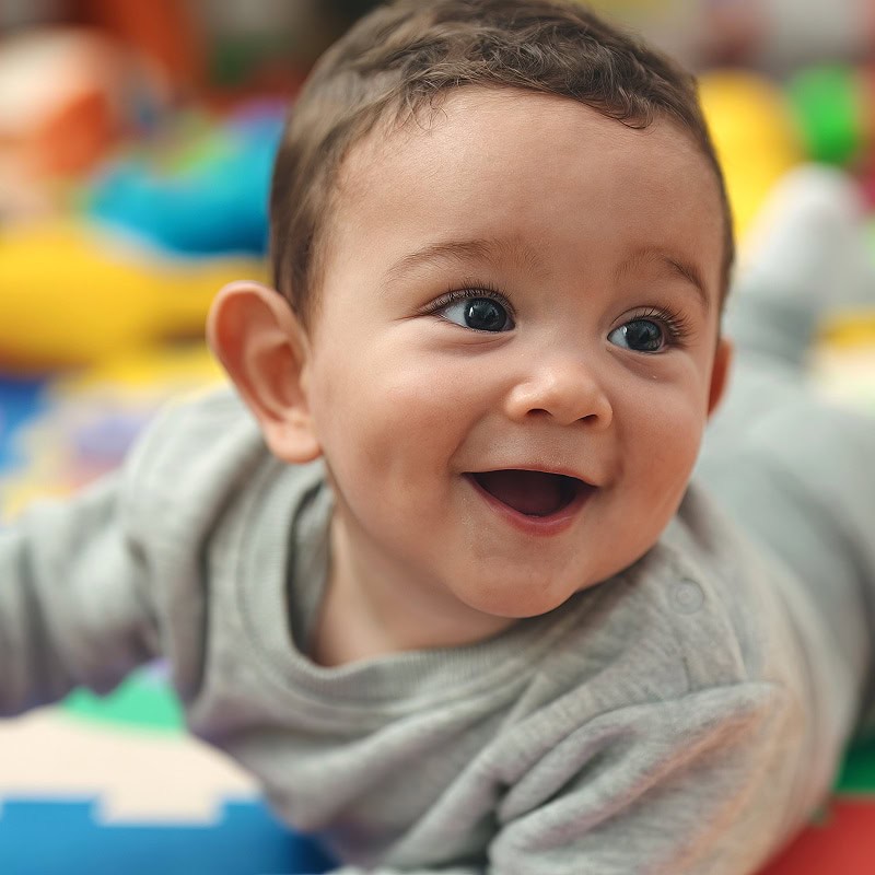 baby smiling on play mat