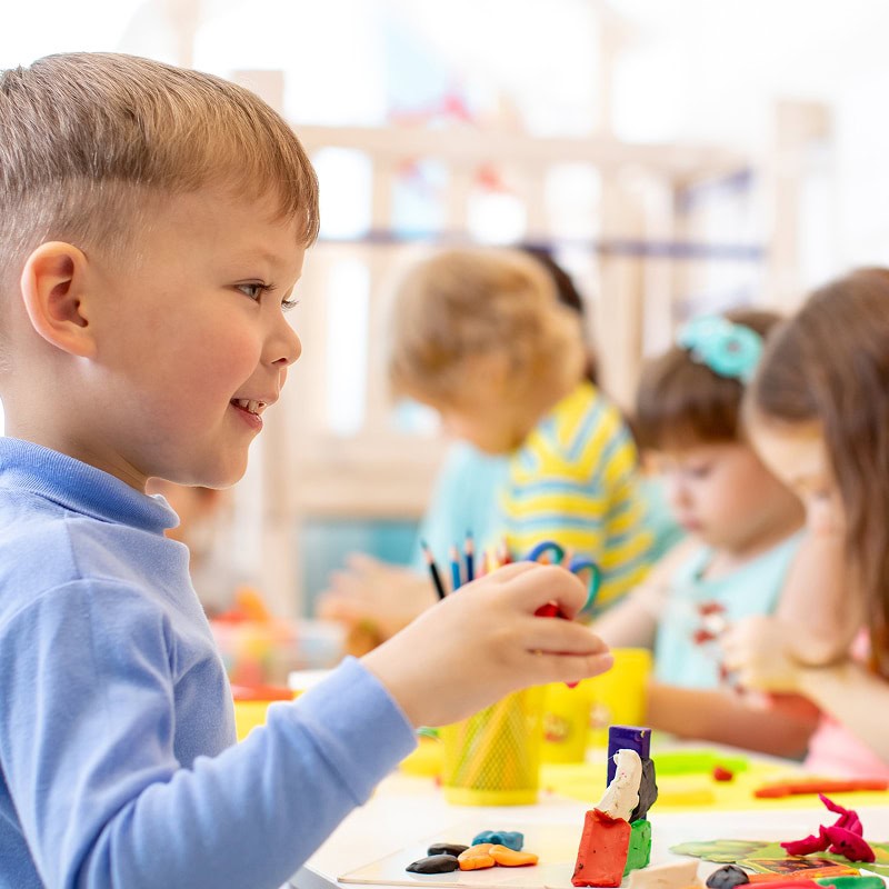 kindergartener playing with clay