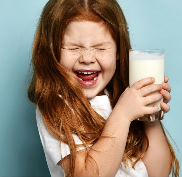 little girl making a face with milk