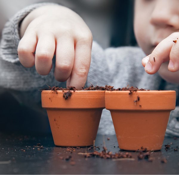 student planting seeds in flower pots