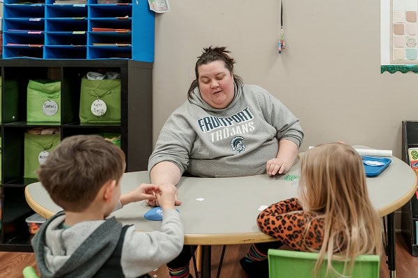 teacher sitting at lunch table with children