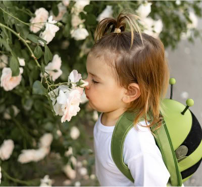 young girl sniffing flowers