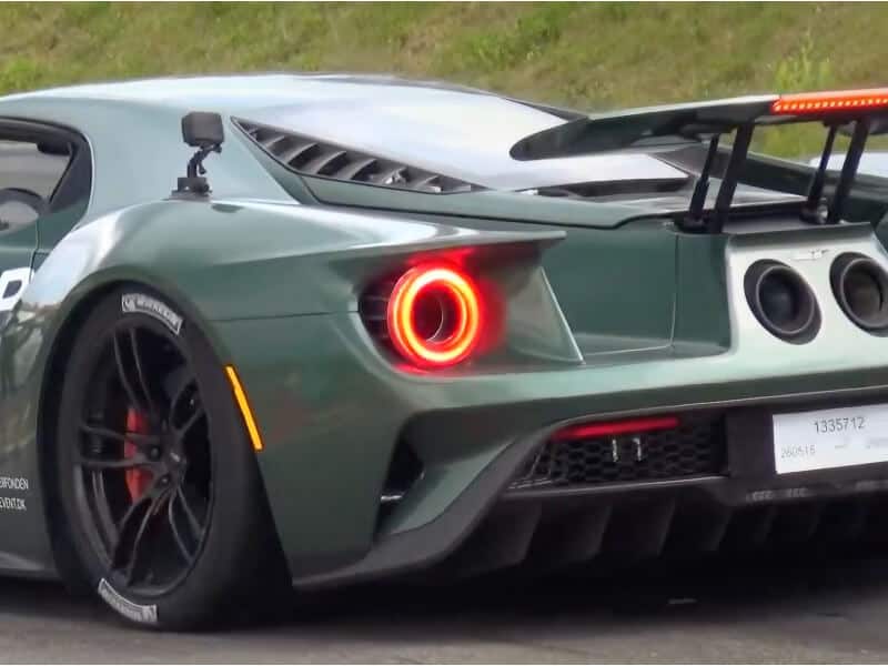 Bagsiden af en grøn Ford GT sportsvogn med tændte baglygter og en stor bagvinge.