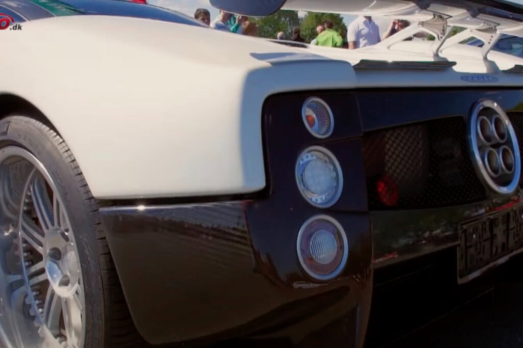 Detalje af pagani zonda sportsvogns baglys og bagdæk med folk i baggrunden.