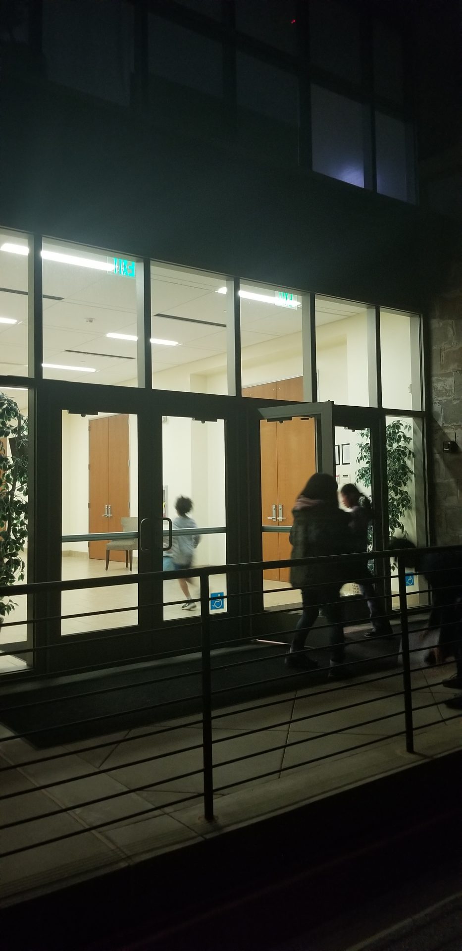 children entering into a building at night time