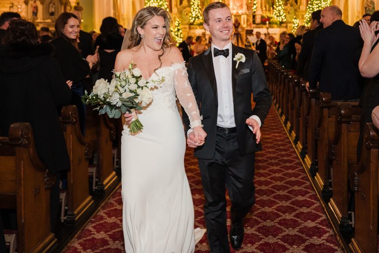 Bride and groom laughing and smiling during their recessional at St. Michael Catholic Church in Chicago, IL