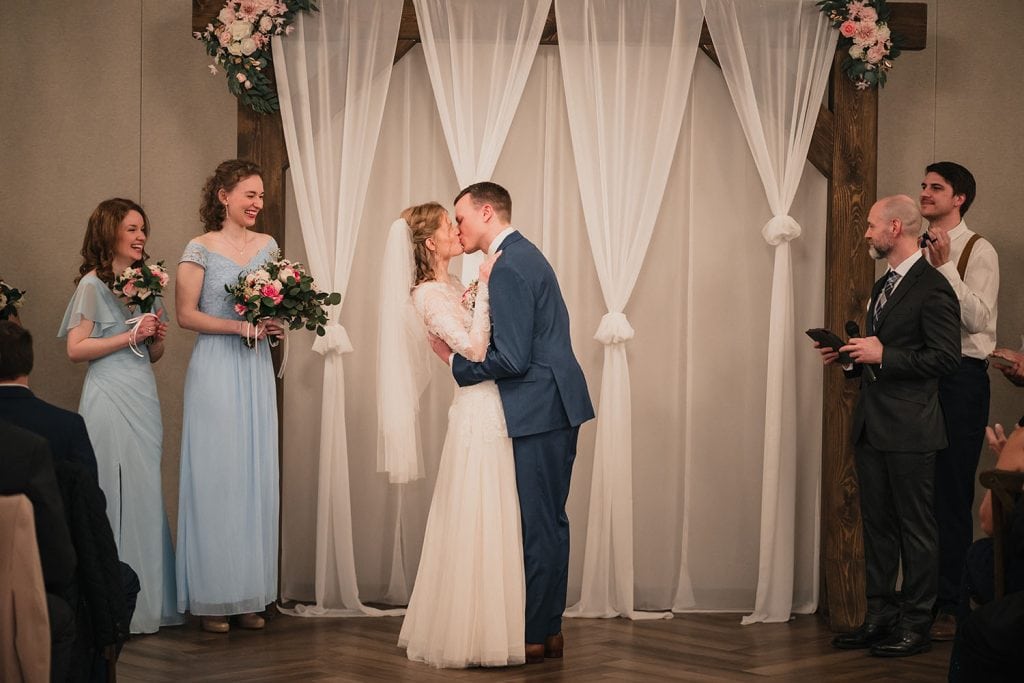 Bride and groom first kiss at the Signature Barn Banquet Hall in Orland Park, IL