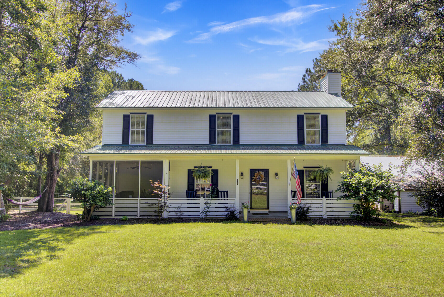 This Farmhouse style, Lowcountry retreat nestled on 2+ acres with direct water access to Awendaw Creek is a MUST see. The property includes a boat shed close to the adjacent community boat landing and private dock on the tidal creek.  This home is conveniently situated near town, yet tucked away from the hustle and bustle. The home has a full front porch and screened in porch along with a detached garage, workshop, and shed. Located on the 1st floor one will find the kitchen, living room, and dining area.  The kitchen features a spacious island, wood countertops, and elegant white subway tile. While there is a designated dining area, the screen porch stands out as the ideal spot for dining, birdwatching, or simply unwinding. The family room provides a warm and inviting atmosphere,complete with a gas log fireplace.  There are also two entry/exit points from the back of the home to the back of the property.

The master suite along with the additional three bedrooms are situated on the upper level. The spacious master bedroom has two closets and an ensuite bathroom. The backyard features a dedicated fire pit area and plenty of open space leading to the water. Enjoy watching morning sunrises or evening sunsets from your private dock. A boat shed and the community boat ramp are located adjacent. 

Well-maintained and thoughtfully updated, the metal roof was put on in 2015 and the HVAC system replaced in 2018. A brand new water filtration system has been added to the well: Ecowater ECR 3700 Water Conditioner, Hydrogen Peroxide System and ERO 385E Reverse Osmosis System.