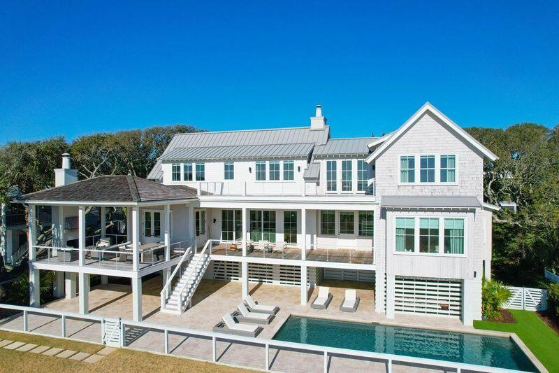 This incredible beachfront residence located OCEANFRONT on the Isle of Palms truly is the best of the best. Designed by the renowned architect Heather Wilson and custom built by Tiller Construction, this 6-bedroom, 6.5-bathroom home will wow your clients at every turn. Inside, the home is custom from head to toe, with an oversized great room featuring wide plank wood floors and a cozy fireplace that flows into the chef's kitchen, complete with subzero and wolf appliances and a center island ideal for entertaining. The luxurious master suite, located on the first floor, has amazing ocean views, custom built in cabinets, large walk-in closet and an amazing shower with full ocean views. Please don't compare this home to other/past IOP oceanfront homes. This lot is 112 feet wide and boost1.97 acres. Due to the rare lot width, the home was design for VIEWS. Which you will find from almost every room in the house. Upstairs features an open den with porch access, along with 3 additional guest bedrooms with ensuite bathrooms. The main floor also has an attached guest cottage with separate lock out entrance. The guest cottage features 2 BR and 2 BA, along with guest den and fireplace... and don't forget the wet bar. Where do we start with the amazing exterior of this home?  The well-appointed landscaping, featuring the charm of live oak trees, in-ground pool, travertine patio, outdoor fireplace and amazing brick driveway, is well thought out in every direction. Last but not least, any golfers out there? Wait until you see the full sized green and chipping area, along with 2 tee boxes to work on your wedge game. Don't let your clients miss out!!