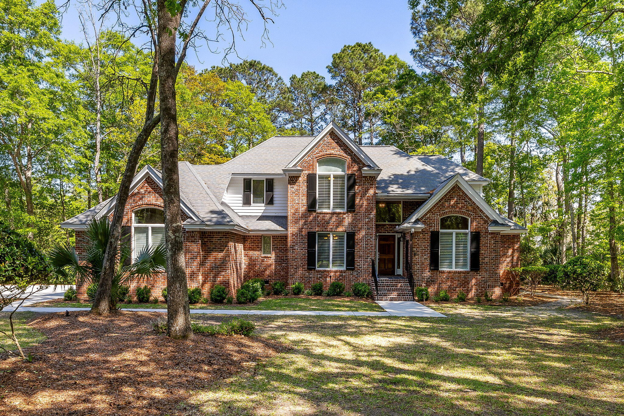 Elegant traditional brick home on an exceptionally private marsh and creekfront estate lot with gorgeous landscaping. The home has a welcoming front porch with ironwork details that leads into a gracious 2-story foyer. There is an office with built-in shelves. The great room has dramatic architectural details including vaulted ceilings and a fireplace. The open kitchen and breakfast area overlook the large deck with views of the beautiful mature trees and marsh.  The primary bedroom is on the ground floor and has a private bathroom with a tub & separate shower.  Upstairs, there are 2 bonus rooms plus three guest rooms and two additional full bathrooms. Dunes West transfer fee is posted as 1/6 of the annual dues on the HOA website.The oversized three-car garage has room for extra storage and shelving. The recently added pebble finished garage floor coating adds a custom look. The spacious laundry room includes storage cabinets, solid surface work counter, soaking sink, storage closet, and room for a second refrigerator or freezer. The home includes plantation shutters, ceiling fans, heavy woodwork, and fine finishes.  In the large open kitchen, there is an island with a Wolf gas cooktop, two ovens, a Bosch dishwasher, stone counters, triple sink, and large storage closet or pantry. There is a second pantry or storage closet in the adjacent laundry room. The crawl space has been encapsulated to prevent moisture buildup underneath the house.  Cherokee Rose Circle is conveniently located near the main entrance security gate on a quiet street with low traffic since it is not a thoroughfare.  The amenities in Dunes West are available by separate membership and are not included in the HOA dues.