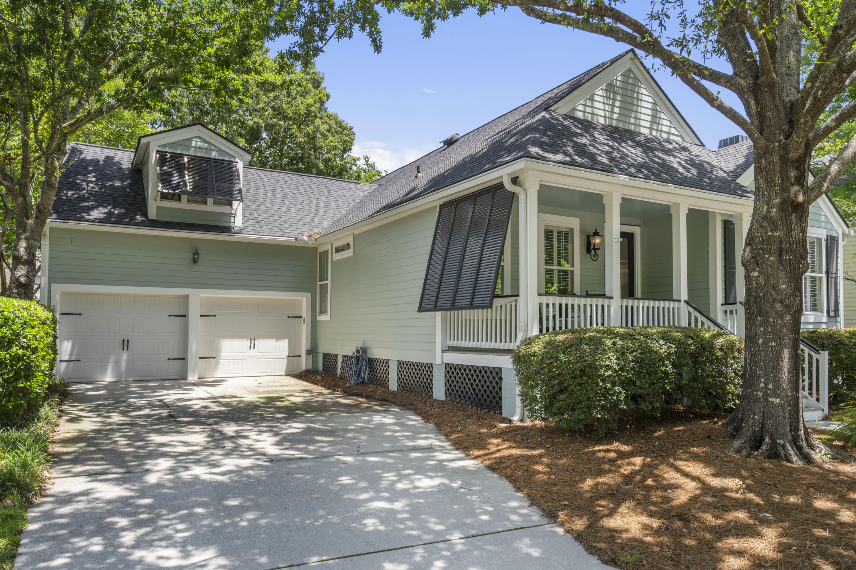 Situated on a tree-lined street, this one-level 3-bedroom 2-bath cottage has many upgrades and is well maintained.  The front porch has a low maintenance composite decking and a new beveled glass front door that greets you.   Once inside the home you will find French white oak flooring through the main first floor and vaulted ceilings allow for a roomy feel in the living/dining space.  A ship-lap wall over the wood-burning fireplace and plantation shutters adorns the windows and gives the living room a southern living feel. Along the foyer, custom wood paneling also links the living/dining area. A new chandelier in the dining room gives extra light for any dinner party. Entering the kitchen, you will find new cabinetry, quartzite counter tops, tile backsplash, stainless steel applianceswhich also include a drawer microwave and café door beverage refrigerator. The enlarged opening between the dining room and kitchen allows the cook to chat with all their party guests.  A covered porch has been added over the kitchen door with direct access to the outdoor decking for a perfect place to grill.  This side decking gives you direct access to the backyard and screen porch.  Upon entering the primary bedroom, you will find a vaulted ceiling with ship-lap paneling, new ceiling fan, plantation shutters and a private door to the expanded screen porch.  Enjoy a morning coffee or an evening of relaxation here.  The primary bathroom has an enlarged walk-in tile shower, heated floors and new cabinetry, counter & mirrors.  Adjacent to the bathroom is the primary closet with custom dresser/shelving & hanging organizer.  Over the two-car garage is a flex space that could be an office/media room or extra family area.  This home is also equipped with an ADA lift with direct access from the garage into the home.  So many features and upgrades to mention here, see the attachment addendum for the details.  Daniel Island amenities include access to 3 pools, tennis/pickle ball courts, walking trails, boat ramp, parks and playgrounds.   If square footage is important, please measure. Listing agent believes all MLS information to be correct to include, but not limited to acreage, flood zone info, taxes, HOA and schools is solely subject to independent verification by buyer/buyer's agent.