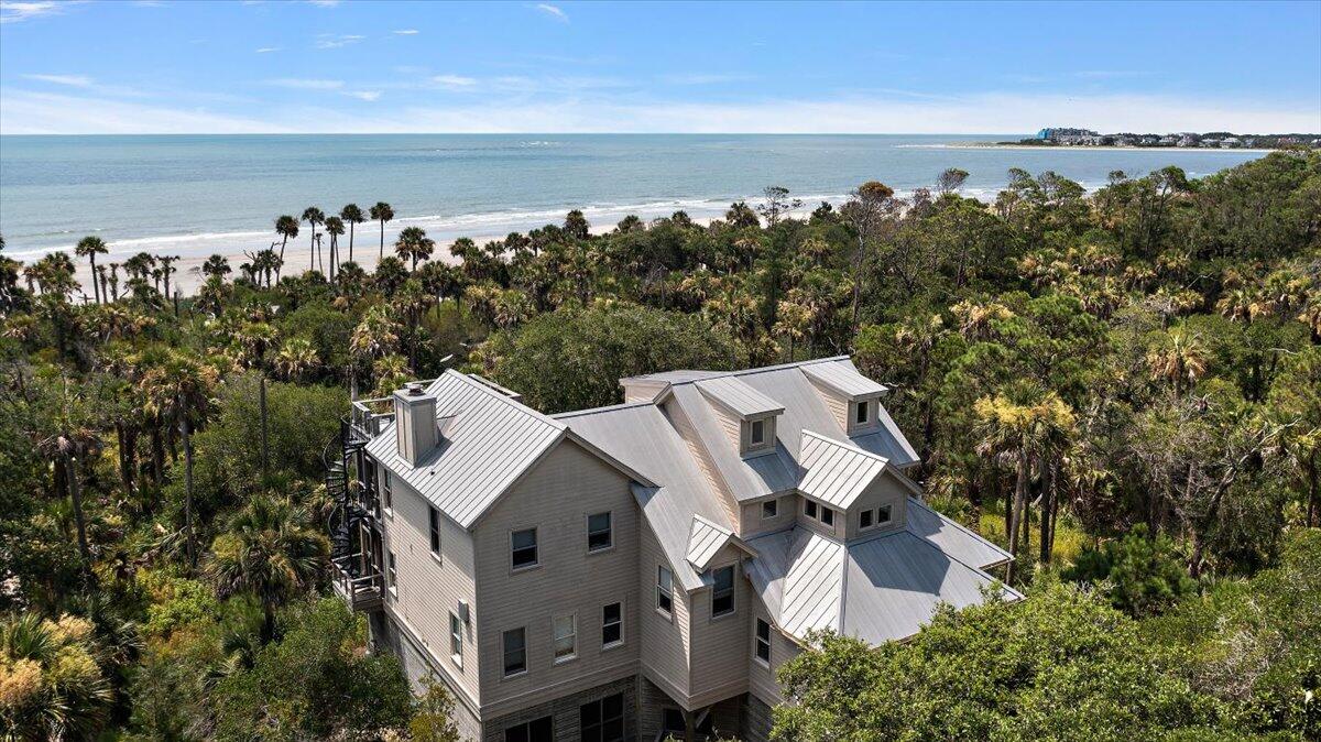 Experience the perfect blend of luxury and simplicity in this exclusive beachfront estate, where privacy, tranquility, and exquisite craftsmanship are evident in every detail. From stunning ocean and beachfront views to impeccable woodworking and a spa-inspired master suite, every inch of this one-of-a-kind property exudes sophistication. The elegant family living areas seamlessly connect to both screened and open-air porches, inviting you to unwind and enjoy the refreshing ocean breeze.Step into the gourmet kitchen, where luxury meets functionality with stunning granite countertops, top-tier recently updated appliances, including an gas range and stainless-steel hood, a premier refrigeration system, premium dishwasher and a built-in microwave. This space is a dream for both chefs and families alike. Adjacent to the living and dining areas is one of three expansive porches, offering a perfect retreat to enjoy year-round. Completing the second floor is the spa-inspired primary suite, designed with a luxurious steam and soaking tub shower, providing the ideal sanctuary for relaxation and privacy.

On the lower level, you'll find four spacious bedrooms, three full bathrooms, a secondary family room, and an additional screened porch, perfect for everyone to enjoy. A generous workshop and storage area provide ample space for all your beach and island essentials, including a stretch golf cart that is included with the property. 

Embrace the ultimate beach lifestyle with your own private dedicated boardwalk reserved for only a few lots leading to a charming gazebo and hammock, exclusively for you and your guests to enjoy.  This furnished and move-in ready home offers everything you need to embrace the Dewees Island lifestyle. The only thing missing is you.