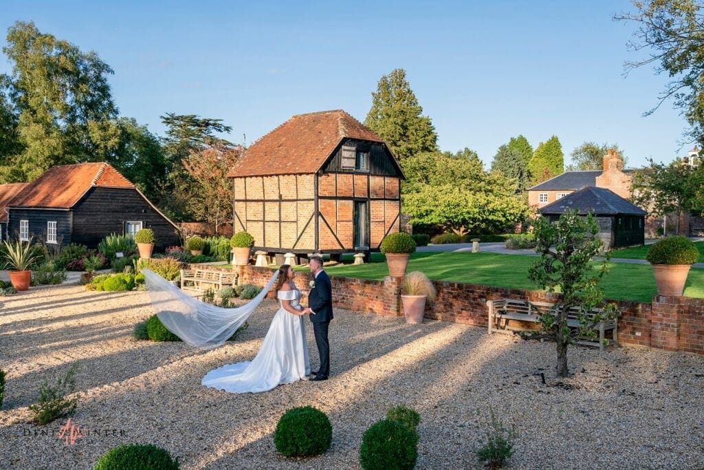 Bride and Groom standing in the courtyard at Wasing Park Barn