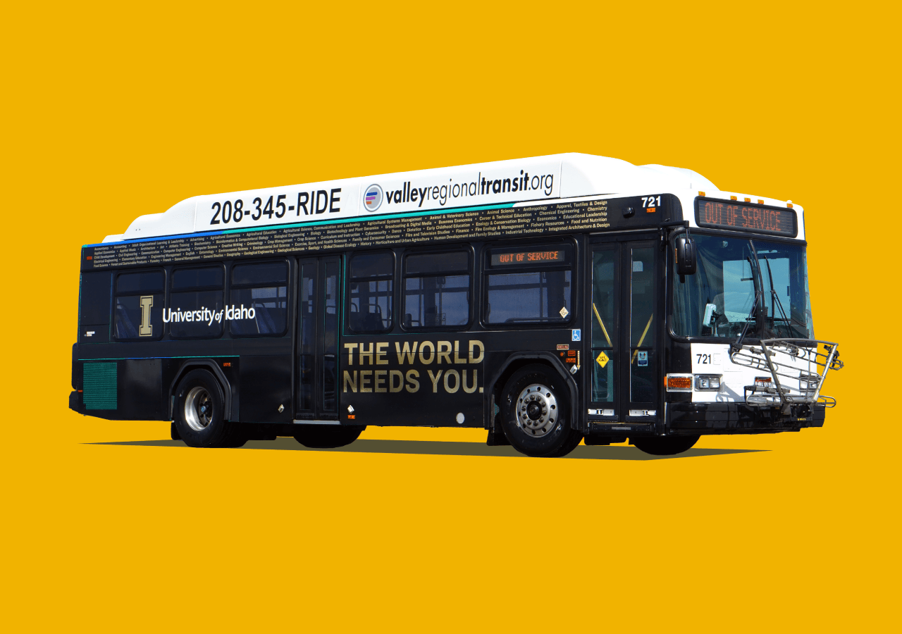 Boise city bus wrapped in black with metallic gold text that reads "the world needs you" and has the University of Idaho logo