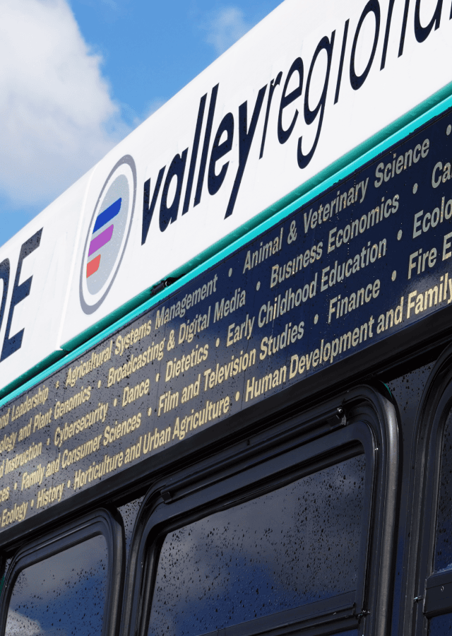 close up shot of Boise city bus with black wrap and multi-line list of all University of Idaho majors in metallic gold