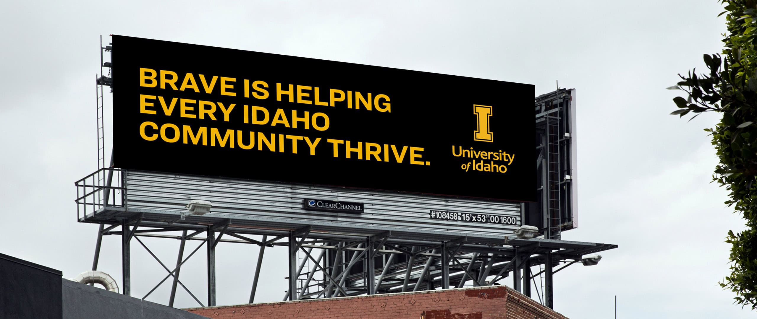 Black out of home billboard with gold text reading "Brave is helping every Idaho community thrive." and the University of Idaho logo to the right of the text