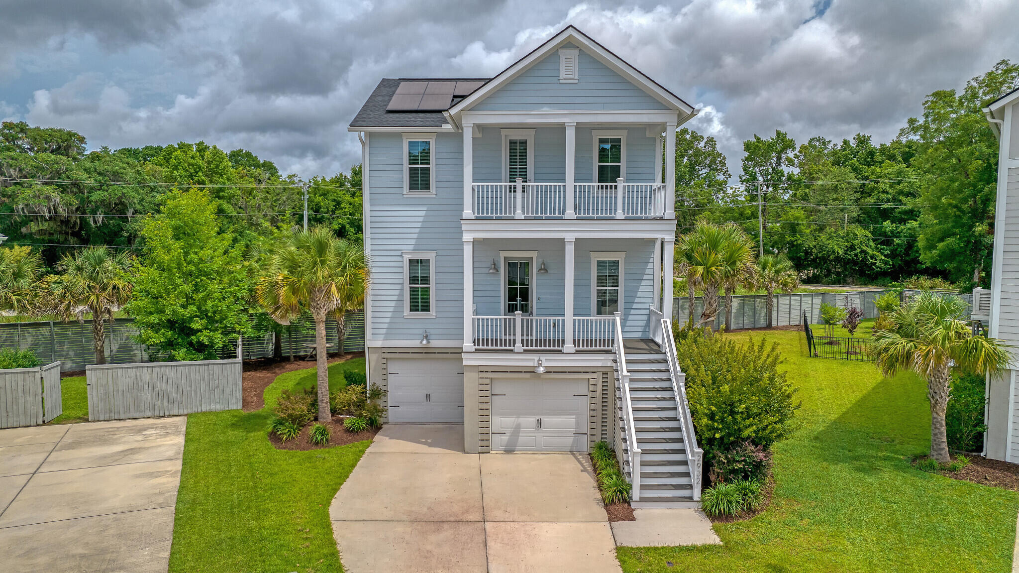 Coastal charm and elegance define this like-new 4-year-old Mount Pleasant home. With 10 ft ceilings, wide plank low-maintenance floors, oak stairs, and an oversized marble kitchen island, it offers luxury at every turn. Featuring 5 bedrooms, 3 full baths, elevated construction with room for 3 cars, and abundant storage, this property is a dream. Nestled in the small, private community of Hamlin Oaks, it exudes quality from the moment you arrive. The inviting double front porches epitomize the low country feel, while inside, a light-filled foyer leads to an open concept dining room and family room with a gas log fireplace and custom built-in cabinets. The beautiful gourmet kitchen boasts floor-to-ceiling white cabinetry, subway tile backsplash, a large island, marble countertops.