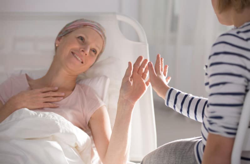 Daughter about to touch hands with mother who is on hospice
