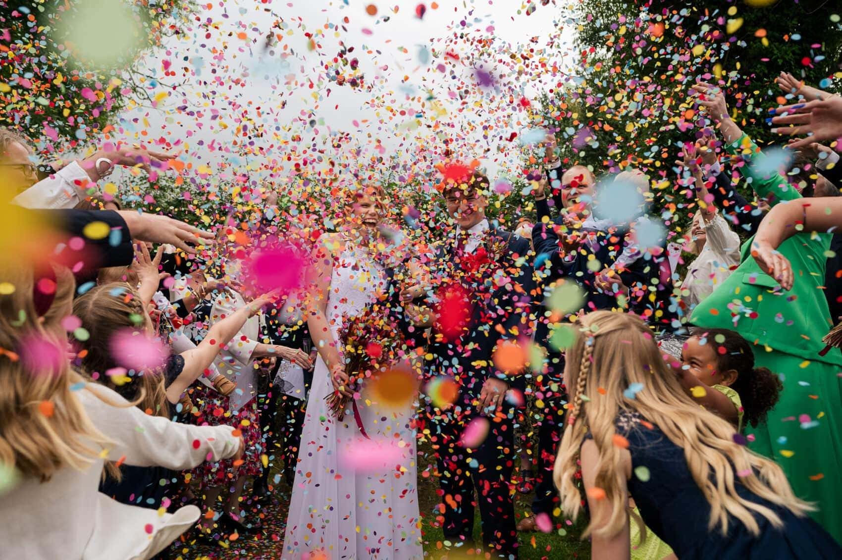 Colourful Confetti coveres a bride and Groom