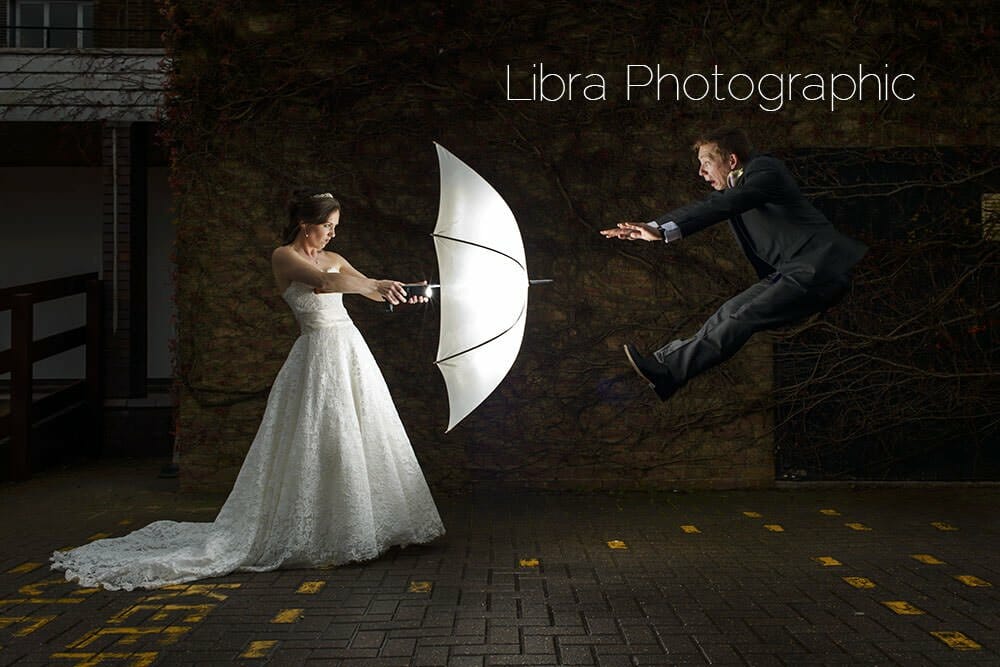 Groom flys away from brides umbrella