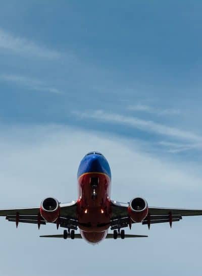 Blue and red airplane flying in blue sky