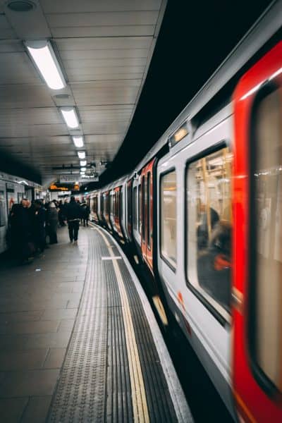 Red subway train arriving at the station along a crowded platform