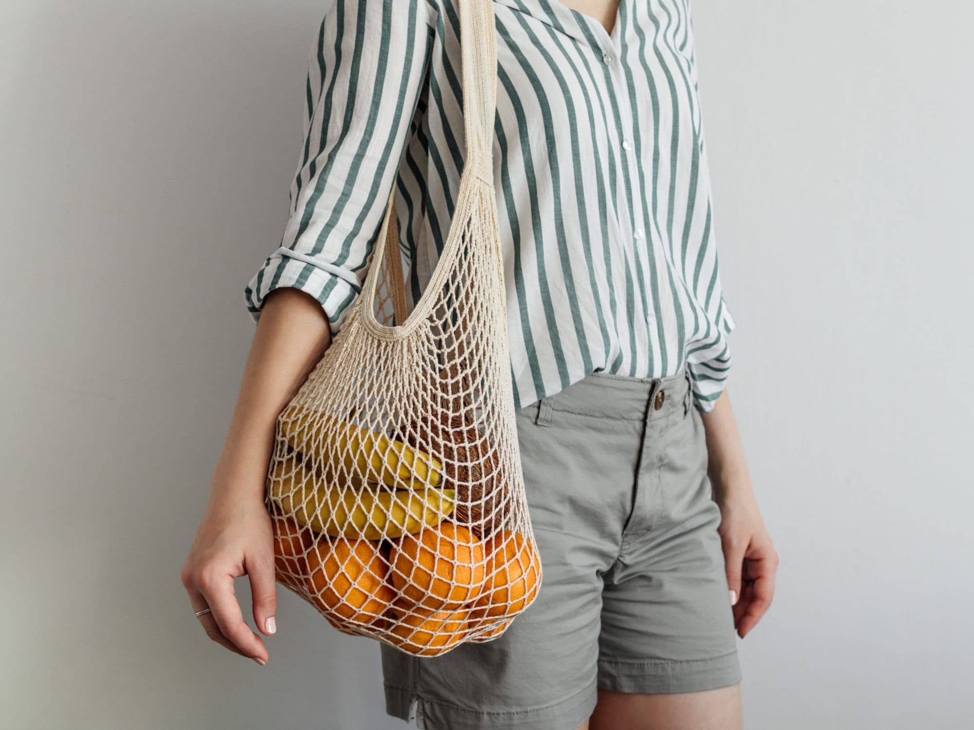 woman with reusable produce mesh bag with fruit