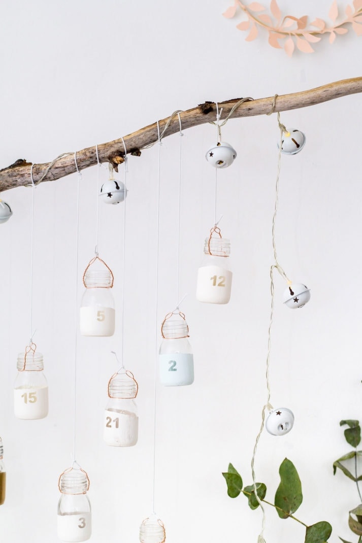 DIY reusable advent calendar with jars hanging from branch