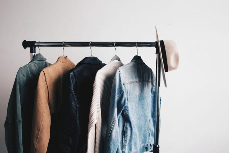 clothes hanging on rack in bedroom