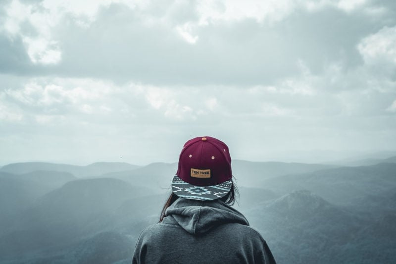 person wearing tentree hat overlooking mountains 