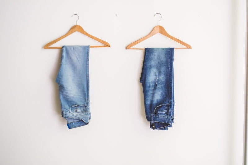 jeans hanging on clothes hangers